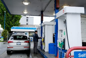 People fill their vehicles at a gas station in east Vancovuer on May 14, 2022, when prices hit $2.28 for a liter of regular gas in Vancouver.