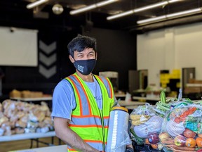 Volunteer Cliff Sapadan preparing packages of food for clients.