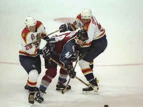 Florida Panthers defenseman Ed Jovanovski and teammate Johan Garpenlov (left) put the squeeze on Colorado Avalanche winger Scott Young during Game 4 of the 1995-96 Stanley Cup Final at Miami Arena on June 10, 1996.