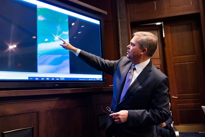 Scott Bray, deputy director of naval intelligence, points to an image on a screen.