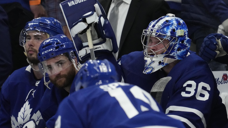 Goaltender Jack Campbell and teammates TJ Brodie and Justin Holl on the Maple Leafs bench.