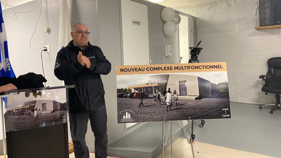 Christian Goulet next to a sign presenting the project.