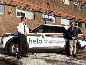 Edmonton Police Service Chief Dale McFee and Mike Ellis, associate minister of mental health and addictions, are seen with a HELP SUV during the Alberta government's announcement of an additional $600,000 in funding for the Edmonton Police Service's Human-centred Engagement and Liaison Partnership (HELP) teams in Edmonton, on Nov. 19, 2021.