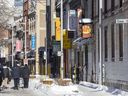 People walk on de La Gauchetière St. in Montreal's Chinatown Sunday Jan. 23, 2022. Quebec's culture and communications ministry announced Monday that parts of Chinatown, including this block, will be classified as a heritage district, protecting it from developers.
