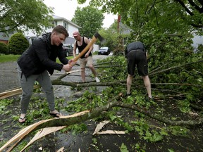 A powerful storm rolled through Ottawa Saturday, downing trees and flooding streets. Neighbours cleaning up on Weston Avenue in Ottawa.