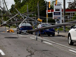 The scene from Merivale Road at Viewmount Drive on Sunday, May 22, 2022. Cars are trapped under wires with many downed hydro poles. Merivale Road is closed in the area.