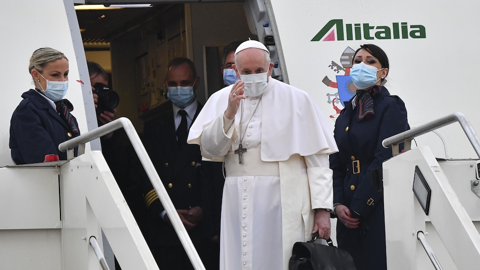 The Pope salutes before entering the plane.