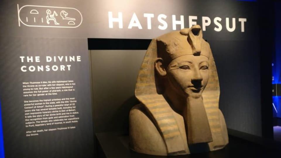Shot of bust of Queen Pharaoh with her name, Hatshepsut, written on the wall above her head.