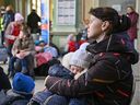 A woman holds her baby as they wait at Przemysl train station before continuing their journey from in war-torn Ukraine on March 23, 2022.
