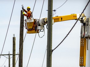 A Hydro worker works on new poles installed after Saturday's storm damage in Ste-Anne-des-Plaines north of Montreal Tuesday May 24, 2022.