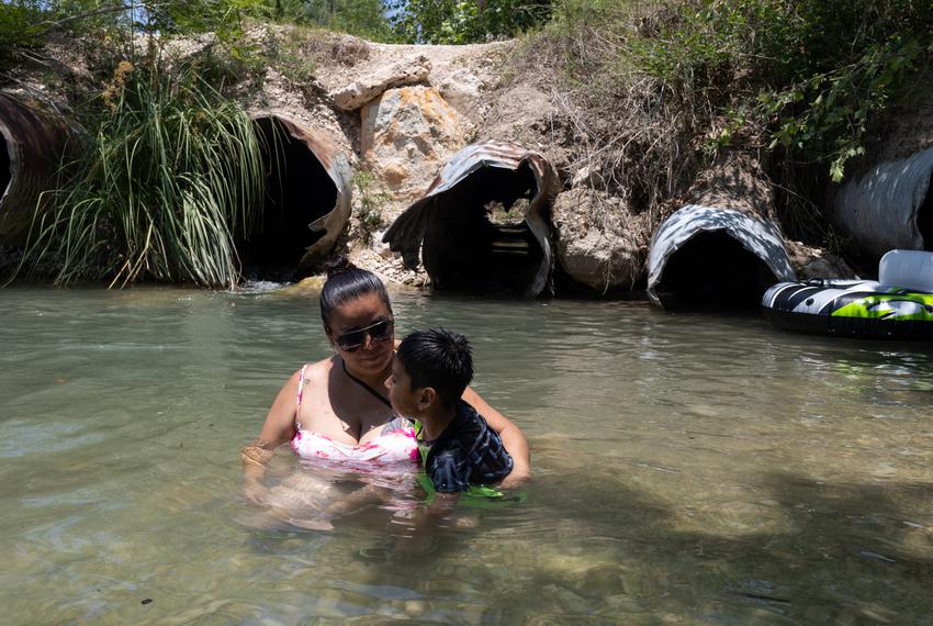 Kimberly Rodriguez, 33, holds her son Jeremy Medina, 5, alongside the shore of the Nueces River outside of Uvalde, on May 28…