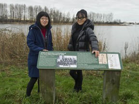 Lorene Oikawa (left), president of the National Association of Japanese Canadians and Susanne Tabata, also of the NAJC, stand near a plaque honoring Japanese Canadians across the Fraser river from Don Island in Richmond, BC Saturday, December 28, 2019. Don Island was previously known Oikawa Island.