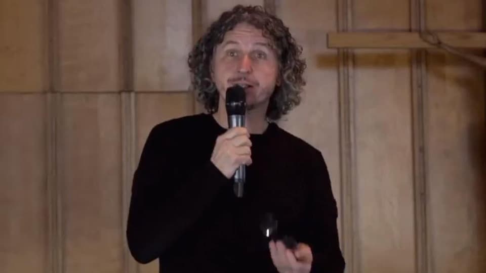 Jeannot Painchaud during a presentation, microphone in hand.