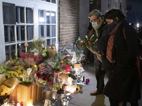 Régis Labeaume, then mayor of Quebec City, brings flowers at a vigil to honor Suzanne Clermont, who was stabbed to death on Oct. 31, 2020.