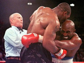 Referee Lane Mills (left) steps in as Evander Holyfield reacts after Mike Tyson bit his ear in the third round of their WBA heavyweight championship fight at the MGM Grand Garden Arena in Las Vegas.  Holyfield won by disqualification after the biting incident.