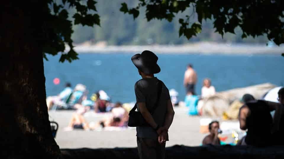 A person looks at the horizon on a beach in Vancouver.