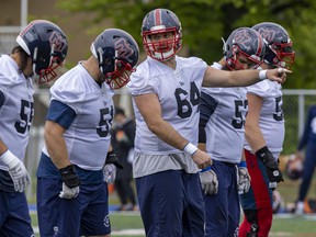 Center Sean Jamieson, 64, points out defensive assignments to fellow offensive linemen during Alouettes training camp in Trois-Rivières on Thursday.
