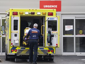 A paramedic loads his stretcher back into the ambulance after bringing a patient to the emergency room at a hospital in Montreal, Thursday, April 14, 2022.