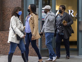 Mask-wearing shoppers exit a downtown shopping mall in Montreal on Wednesday, May 4, 2022.