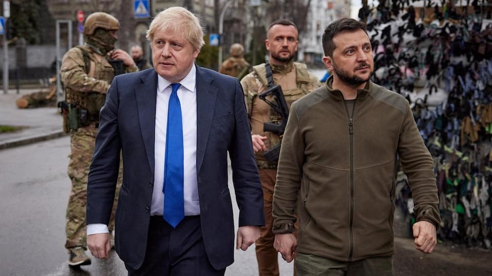 Boris Johnson and Volodymyr Zelensky walk side by side down the street. 