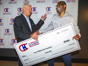 Réjean Houle, left, president of the Montreal Canadiens Alumni Association, with Trevor Williams, holding a check from the Montreal Canadiens Children's Foundation at the Bell Center in Montreal on Tuesday, May 17, 2022. Houle is a member of the Foundation's board of directors , while Williams runs the Trevor Williams Kids Foundation.