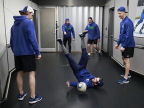 Conor Garland of the Vancouver Canucks falls to the ground as he kicks a soccer ball before their NHL game against the Arizona Coyotes at Rogers Arena April 14, 2022.