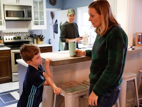 Helen McClenahan talks to her son Oakes, 7, as the family begins the work and school day from home in Seattle.