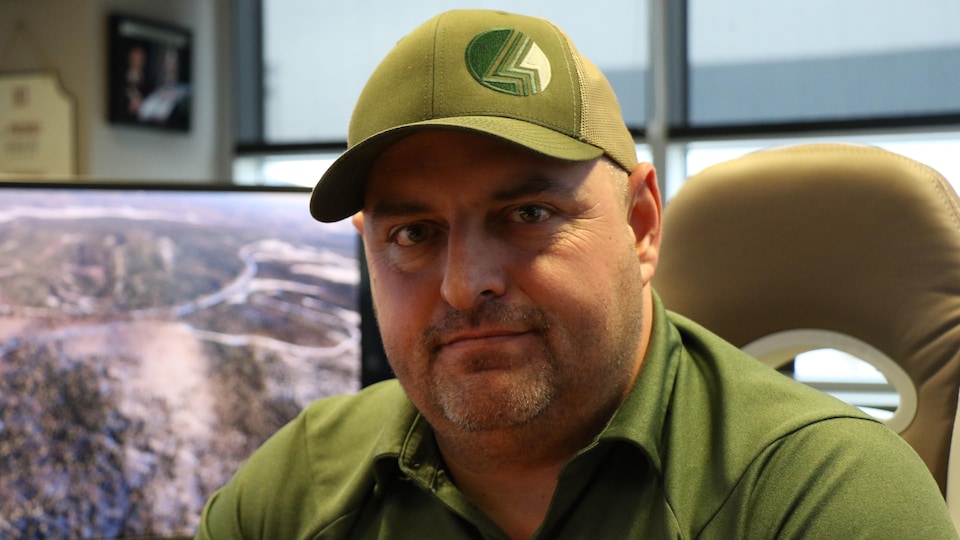 A man from the front with a cap and a green polo shirt