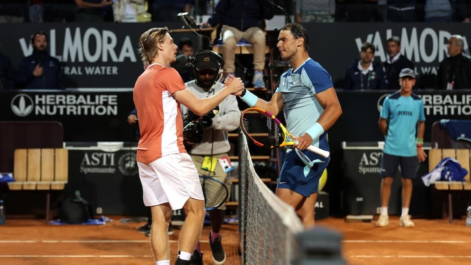 Two tennis players shake hands after a match.