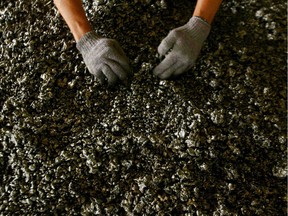 A worker displays nickel ore in a ferronickel smelter.