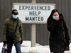 Pedestrians make their way past a help wanted sign at a Jiffy Lube location, 9927 82 Ave., in Edmonton, on Tuesday March 15, 2022.