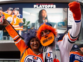 Oilers fans Jesse and Neil Pandya cheer during the Ford Tailgate Party outside of Rogers Place before watching Game 7 of the NHL Stanley Cup playoffs series between the Edmonton Oilers and the LA Kings in Edmonton, on Saturday, Nov. 14, 2022.