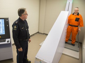 An Edmonton Remand Official demonstrates a scanner designed to reduce the amount of contraband entering the facility.  A judge this week recommended random screening for remand center employees following a report on two 2016 overdose deaths.