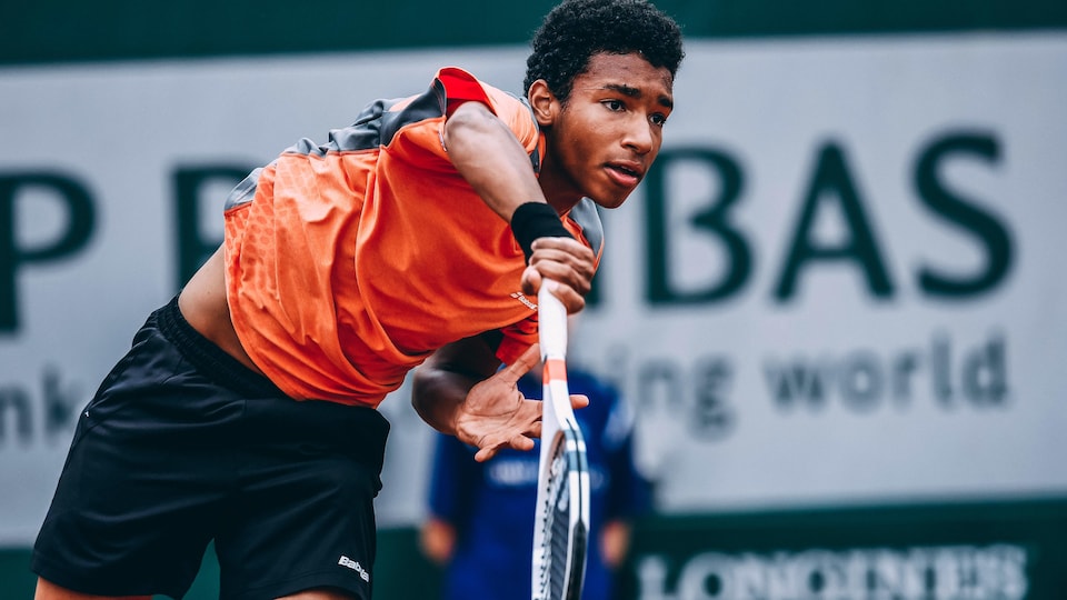 Félix Auger-Aliassime performs a service during the final of the French Open junior tournament in the summer of 2016, against Frenchman Geoffrey Blancaneaux.