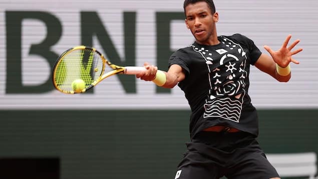 Felix Auger-Aliassime hits the ball.  