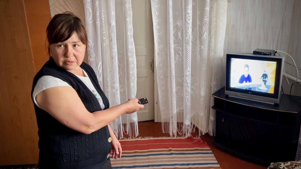 A woman in front of a television set.