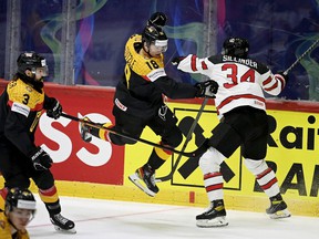 Canada's forward Cole Sillinger (right) and Germany's forward Tim Stutzle (centre) vie for the puck during the IIHF Ice Hockey World Championships group A match between Germany and Canada at the Helsinki ice Hall in Helsinki, Finland, on May 13, 2022.