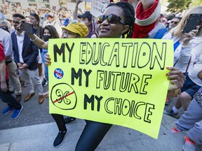 A woman holds a sign during the rally to oppose Bill 96 in Montreal on Saturday May 14, 2022. The debate over the language bill has awoken long-dormant tensions between English- and French-speaking Quebecers and revived historical grudges that seemed to belong to a bygone era, Allison Hanes writes.