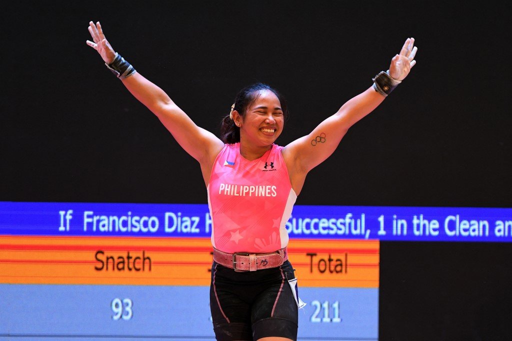 Hidilyn Diaz of the Philippines celebrates her victory in the women's 55kg powerlifting event during the 31st SEA Games in Hanoi on May 20, 2022. (Photo by Tang Chhin Sothy and TANG CHHIN SOTHY / AFP)