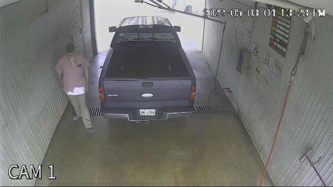 A man stands next to a truck that U.S. Marshals say was being driven by Alabama inmate Casey White at the Weinbach Car Wash in Evansville, Indiana.  The truck was found abandoned there on Sunday, May 8.  White escaped from an Alabama prison with former corrections officer Vicky White last week.