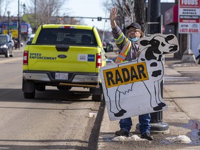 Dean Hill warns passing motorists about the photo radar truck that is stopped on 118 Avenue on Tuesday, March 22, 2022 in Edmonton.  He has been doing this for the past four years and has been charged with various offenses for doing so.