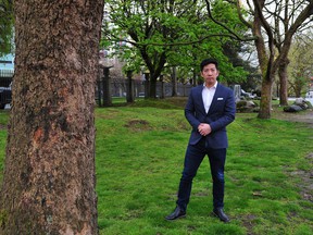 Michael Tan of the Chau Luen Society poses outside 325 Keefer St. with trees the society is hoping to cut down for property development in Vancouver