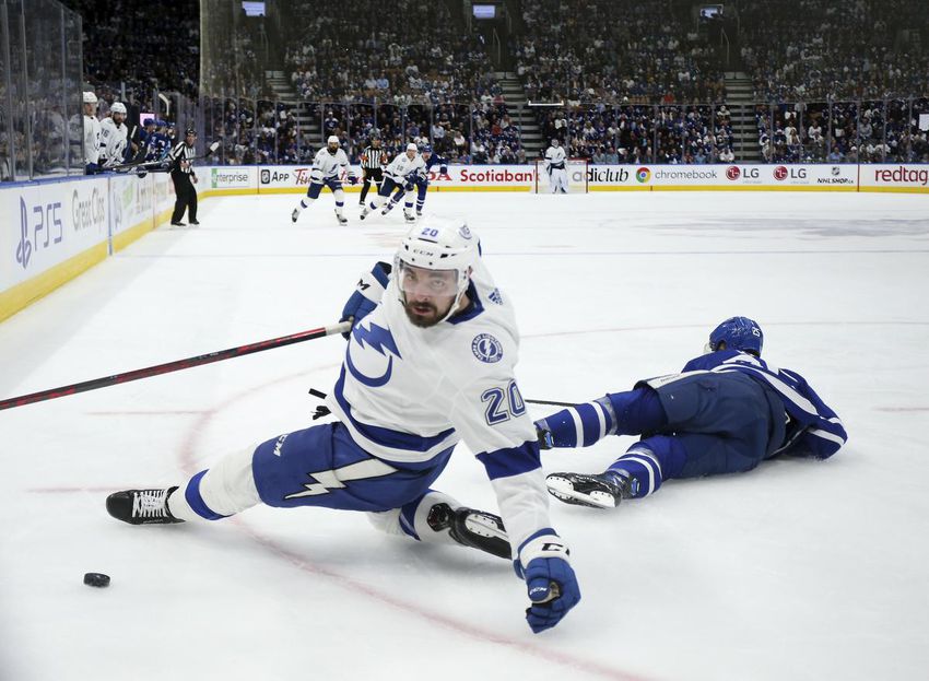 Nicholas Paul (20) of the Tampa Bay Lightning goes down in the corner after battling for the puck with Ondrej Kase (25) of the Toronto Maple Leafs in Game 5 of their first-round playoff series Tuesday.