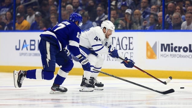 Morgan Rielly and Alex Killorn battle for the puck. 