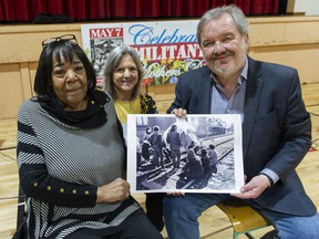 Barbara Burnet, Wendy Kyer and Shane Simpson with a Vancouver Sun photograph from 1971 at Admiral Seymour Elementary School in Vancouver.  Burnet was one of the Militant Mothers of Raymur who occupied train tracks near the school in 1971 because they feared for the safety of their children trying to cross the tracks on their way to school.  Kyer was a former student at the school who used to cross the tracks, as was Simpson.