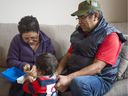 Ingrid Mendez and Byron Cruz of Sanctuary Health play with 'Leo' while visiting a family in Metro Vancouver on Saturday.  Richard Lam/PNG