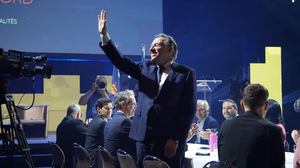 François Legault got up from the meeting table, raised his arm in the air to greet those present. 