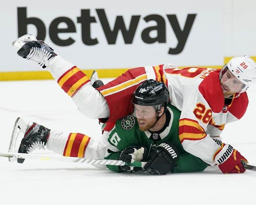 Calgary Flames center Elias Lindholm (28) and Dallas Stars center Joe Pavelski go down during the first period of Game 3 of an NHL hockey Stanley Cup first-round playoff series on Saturday, 7 May 2022 in Dallas.