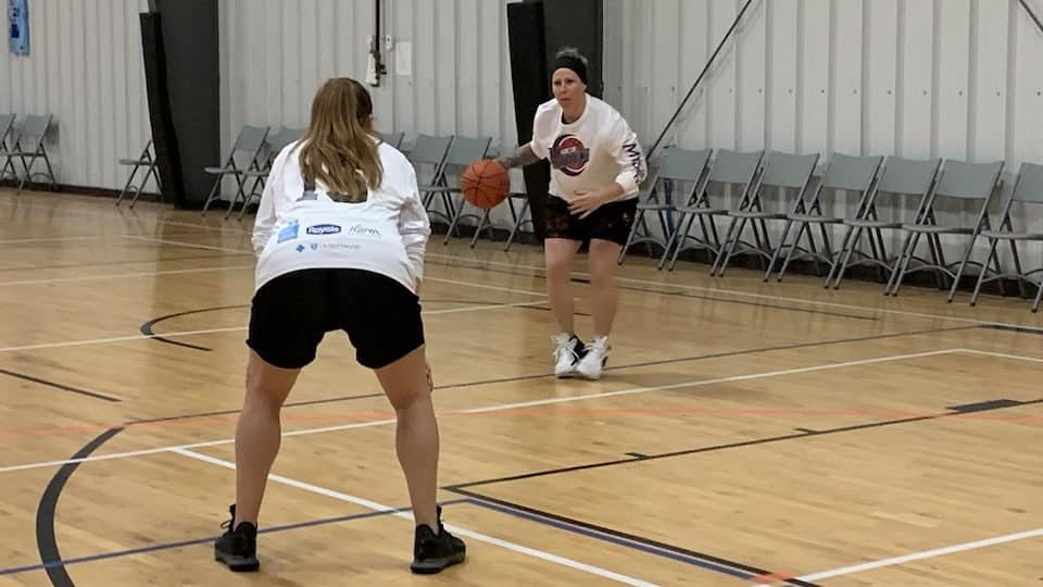 Two women are playing basketball