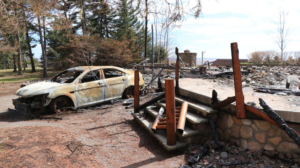 The charred ruins of a chalet and the carcass of a burnt-out car.